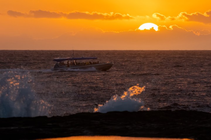 a sunset over a beach next to the ocean