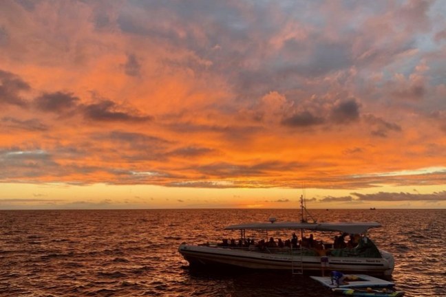 Sunset behind manta ray snorkel boat in Kona, Hawaii