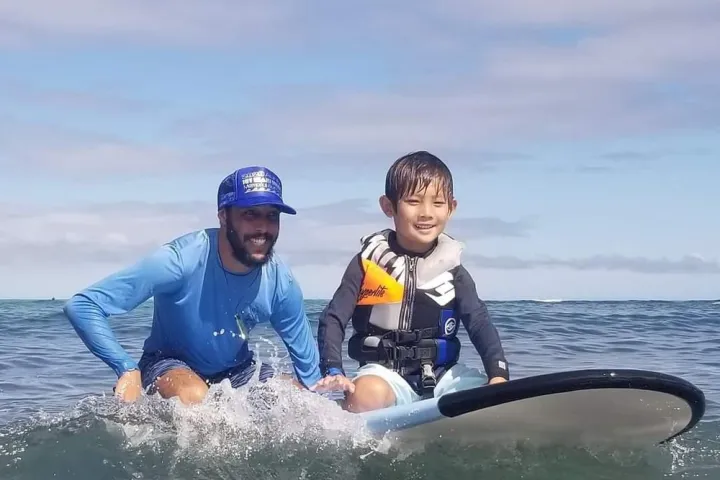 a young girl riding a wave on a surfboard in the water