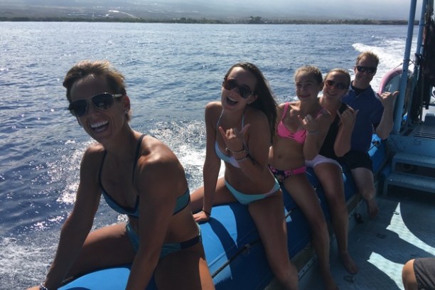 a group of people sitting in front of a body of water