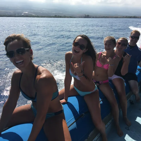 a group of people sitting next to a body of water