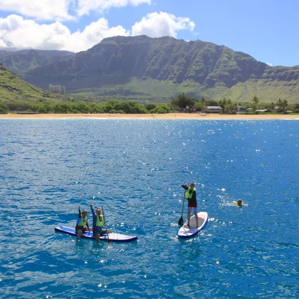 a small boat in a body of water with a mountain in the background